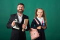 School girl with funny amazed teacher in school. Studio portrait of tutor and young school girl with backpack and