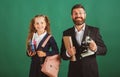 School girl with funny amazed teacher in school. Studio portrait of tutor and young school girl with backpack and