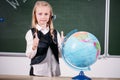 School girl with globe in classroom chalkboard on background Royalty Free Stock Photo
