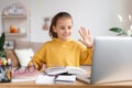 School girl having online lesson at home via laptop webcam Royalty Free Stock Photo