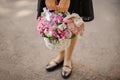 School girl holding a cute wicker basket full of bright pink flowers decorated with a toy rabbit