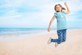 School girl jumping on beach near sea, space for text. Summer holidays Royalty Free Stock Photo