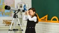 School girl looking through telescope. Little girl using telescope. Telescope on tripod. School subjects set. School Royalty Free Stock Photo
