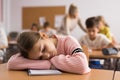 School girl lying and sleeping at desk Royalty Free Stock Photo