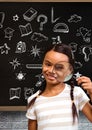 School girl with magnifying glass and Education drawing on blackboard for school