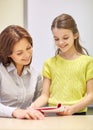 School girl with notebook and teacher in classroom