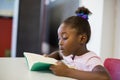 School girl reading book in classroom Royalty Free Stock Photo