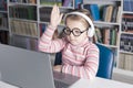 School girl is studying online. Home schooling. Distance education. The girl raises her hand to answer the teacher Royalty Free Stock Photo