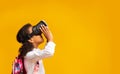 School Girl In Virtual Reality Headset Standing, Yellow Background, Side-View