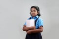 A school girl wearing uniform holds note books in hand Royalty Free Stock Photo