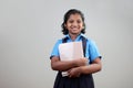 A school girl wearing uniform holds note books in hand Royalty Free Stock Photo