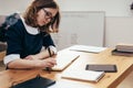 School Girl writes in a notebook sitting at table Classwork, homework