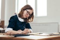 School Girl writes in a notebook sitting at table Classwork, homework Royalty Free Stock Photo