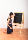 School girl writing Albert Einstein equation on blackboard