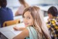 School girl writing on paper in classroom Royalty Free Stock Photo