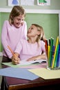 School girls writing in notebook in classroom Royalty Free Stock Photo