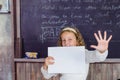 School is a happy place. Happy small child holding blank paper on blackboard background. Little girl happy smiling with Royalty Free Stock Photo