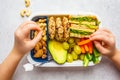 School healthy lunch box with sandwich, cookies, fruits and avocado on white background Royalty Free Stock Photo