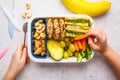 School healthy lunch box with sandwich, cookies, fruits and avocado on white background Royalty Free Stock Photo