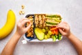 School healthy lunch box with sandwich, cookies, fruits and avocado on white background Royalty Free Stock Photo