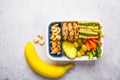 School healthy lunch box with sandwich, cookies, fruits and avocado on white background Royalty Free Stock Photo