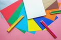 School and hobby concepts. Colorful colored paper sheets, colored pencils and open sketchbook. Copy space Royalty Free Stock Photo