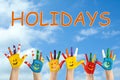 School holidays. Children with painted palms and blue beautiful sky on background Royalty Free Stock Photo