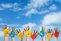 School holidays. Children with painted palms and blue beautiful sky on background Royalty Free Stock Photo