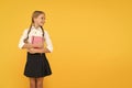 School information. Small child holding time book with information on yellow background. Little girl taken book from