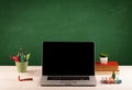 School items on desk with empty chalkboard Royalty Free Stock Photo