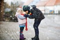 School kid boy and brother warming hands of little sister, toddler girl on cold snowy grey winter day. Family, two Royalty Free Stock Photo