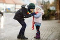 School kid boy and brother warming hands of little sister, toddler girl on cold snowy grey winter day. Family, two Royalty Free Stock Photo