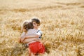 School kid boy and little sister, preschool girl hugging on wheat field. Two happy children playing together and having Royalty Free Stock Photo