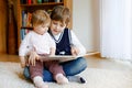 School kid boy reading book for little toddler baby girl, Two siblings sitting together and read books. Beautiful lovely Royalty Free Stock Photo