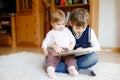 School kid boy reading book for little toddler baby girl, Two siblings sitting together and read books. Beautiful lovely Royalty Free Stock Photo