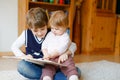 School kid boy reading book for little toddler baby girl, Two siblings sitting together and read books. Beautiful lovely Royalty Free Stock Photo