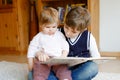 School kid boy reading book for little toddler baby girl, Two siblings sitting together and read books. Beautiful lovely Royalty Free Stock Photo