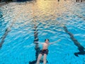 School kid boy splashing in an outdoor swimming pool on warm summer day. Happy healthy preteen child enjoying sunny