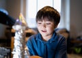 School kid making spaceship for his homework, Happy child boy sitting on the floor playing with rocket toy, Art and craft activity Royalty Free Stock Photo