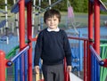 School kid playing in the playground with a funny face,Cute little boy closing eyes while playing in the playground because of the Royalty Free Stock Photo