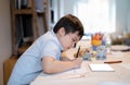 School Kid using colour pen drawing and painting on white paper sheet, A boy doing online home work by using tablet, Child Royalty Free Stock Photo