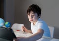 School kid using tablet for his homework,Child boy doing homework by using digital tablet searching information on internet after Royalty Free Stock Photo