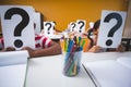 School kids covering their face with question mark sign Royalty Free Stock Photo