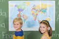 School kids pointing at map in classroom