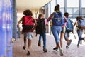 School kids running in elementary school hallway, back view Royalty Free Stock Photo