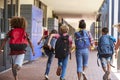 School kids running in elementary school hallway, back view Royalty Free Stock Photo