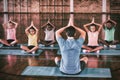 School kids and teacher meditating during yoga class