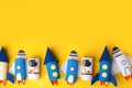 School kindergarten crafts, paper spaceship, shuttle, astronaut on yellow background with copy space for text. Party, start up