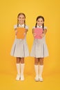 School library. Homeschooling concept. Literacy club. Cute children holding books on yellow background. Little girls