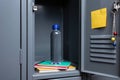 School Locker Interior with Water Bottle, Notebooks, and Yellow Sticky Note Royalty Free Stock Photo